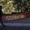 Students walk past a sign that reads "perseverance conquers" 