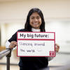 Melanie Smith stands with a sign "My big future: Dancing Around the World"