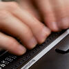 hands using braille reader